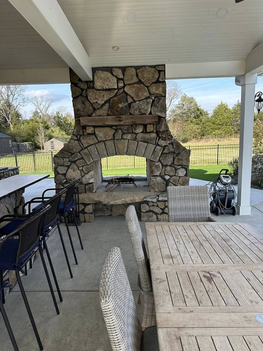 Covered stone fireplace lounge at twilight