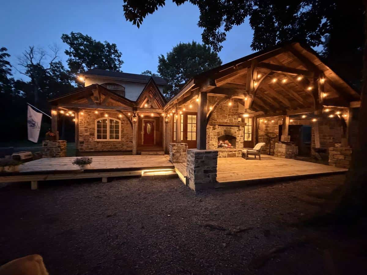 Timber-frame stone pavilion lit at twilight